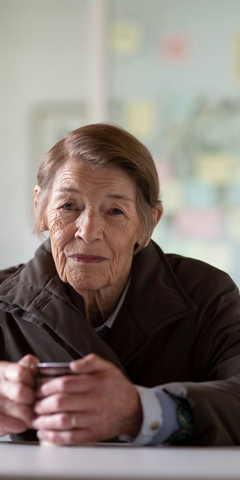 Woman sitting and holding a mug.