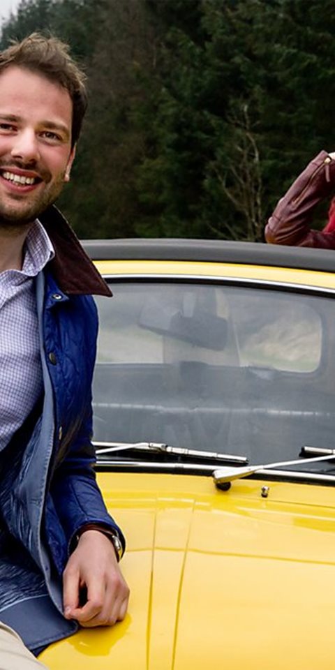 Man and woman standing by a car.